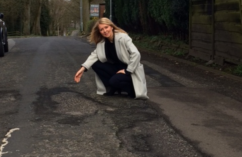 Esther McVey inspects a road with potholes in Cheshire East